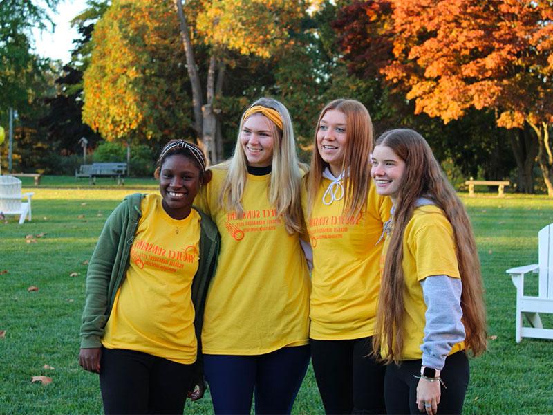 Four young women in yellow t-shirts